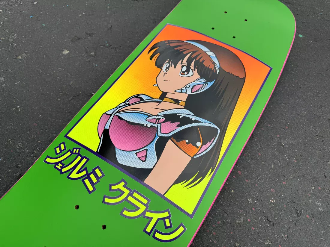 A bright green Hook Ups skateboard deck featuring retro 90s-style anime character art of a woman in futuristic armor with Japanese Katakana text below.
