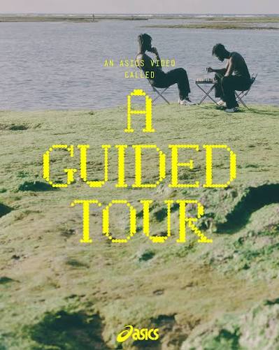 Two people on folding chairs sketching by a lake, overlaid with yellow text: "An Asics video called 'A Guided Tour'."