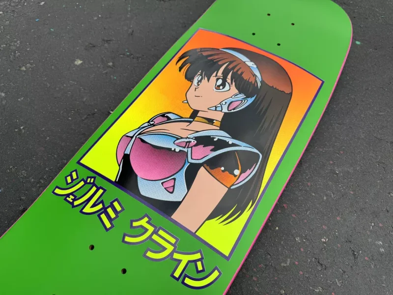 A bright green Hook Ups skateboard deck featuring retro 90s-style anime character art of a woman in futuristic armor with Japanese Katakana text below.